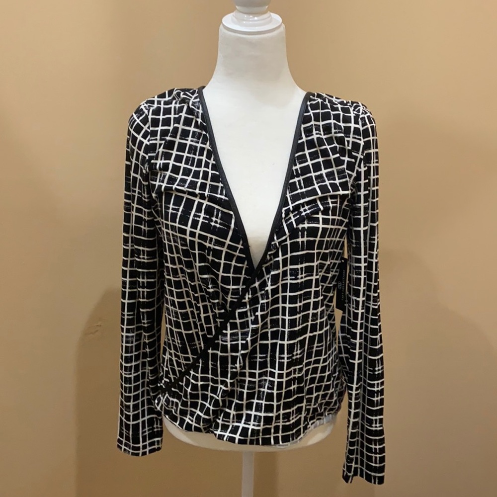 Long sleeve wrap blouse with faux leather trim.